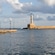 Un puerto con un camino a pie, arquitectura veneciana y un faro cercano